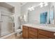 Bathroom with double vanity sink, framed mirror and glass shower enclosure at 2230 Valentia St, Denver, CO 80238