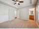 Bedroom with ensuite bathroom and walk in closet features neutral carpet and ceiling fan at 2230 Valentia St, Denver, CO 80238