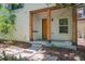 Inviting front porch with wooden beams and decorative front door, and manicured landscape at 2230 Valentia St, Denver, CO 80238