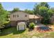An aerial view of the backyard and patio of a two-story brick home with mature trees at 6411 W 82Nd Dr, Arvada, CO 80003