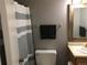 Neutral bathroom featuring a toilet and vanity with a framed mirror and a striped shower curtain at 6411 W 82Nd Dr, Arvada, CO 80003