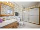Bathroom with floral wallpaper, wood vanity, and shower-tub combo at 6411 W 82Nd Dr, Arvada, CO 80003