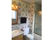 Bathroom features floral wallpaper, wooden vanity, mirror cabinet, and a shower with gold frame at 6411 W 82Nd Dr, Arvada, CO 80003