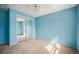 Bright bedroom with neutral carpet, blue walls, and a closet with mirrored sliding doors at 6411 W 82Nd Dr, Arvada, CO 80003