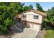 Two-story home with an attached two-car garage and mature trees in a well-kept front yard at 6411 W 82Nd Dr, Arvada, CO 80003