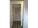 Hallway showcasing gray plank flooring and a classic white door with louvers at 6411 W 82Nd Dr, Arvada, CO 80003