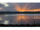 Scenic lake view at sunset with orange sunlight reflecting on the water and mountains in the distance at 6411 W 82Nd Dr, Arvada, CO 80003