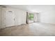 Bright living room with a large window, a door to the front entrance, and neutral-colored carpet at 6411 W 82Nd Dr, Arvada, CO 80003
