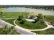 Aerial view of a large park with mature trees, walking paths, a playground, and a lake beyond at 6411 W 82Nd Dr, Arvada, CO 80003