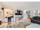 Bright living room featuring a brick fireplace, wood floors, and modern media center at 5255 S Waco St, Centennial, CO 80015