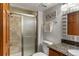 Bathroom featuring a glass door shower and a granite-top vanity at 8571 W 71St Cir, Arvada, CO 80004