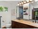 Bathroom featuring a wood vanity with double sinks and large mirrors at 8571 W 71St Cir, Arvada, CO 80004