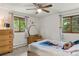 Bright bedroom with two windows, a ceiling fan, and a dresser with vanity at 8571 W 71St Cir, Arvada, CO 80004