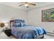 Bedroom featuring a bed with blue patterned bedding, side table, and natural light from the window at 8571 W 71St Cir, Arvada, CO 80004