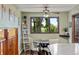 Cozy dining area featuring a round table, ladder shelving, and a large window with backyard views at 8571 W 71St Cir, Arvada, CO 80004
