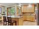 Open kitchen with light wood cabinets, a peninsula with bar seating, and tiled floors at 8571 W 71St Cir, Arvada, CO 80004