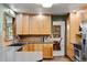Bright kitchen featuring light wood cabinets, tile backsplash, and an adjoining dining area at 8571 W 71St Cir, Arvada, CO 80004