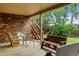 Covered patio featuring a rocking chair, seating area, and access to the yard with a slide at 8571 W 71St Cir, Arvada, CO 80004