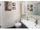 Bathroom features a modern sink, floating glass shelf, and a collection of artful wall decor at 836 E 17Th Ave # 2B, Denver, CO 80218