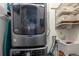 Convenient laundry room with a modern, front load washer and dryer, along with storage shelving at 836 E 17Th Ave # 2B, Denver, CO 80218