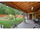 Backyard with a covered patio, string lights, a small tree, and a lush lawn at 1470 S Yates St, Denver, CO 80219