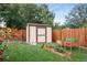 Backyard with a shed, wooden fence, and raised garden beds at 1470 S Yates St, Denver, CO 80219