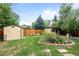 Large grassy backyard with a shed, wooden fence and many raised flower beds at 1470 S Yates St, Denver, CO 80219