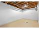 Unfinished basement with an exposed ceiling and a drain in the center of the room at 1470 S Yates St, Denver, CO 80219