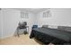 Neutral bedroom with tiled floor, features a black bed, blue chair and workspace at 1470 S Yates St, Denver, CO 80219
