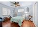 Bedroom with wood floors, ceiling fan, and large windows at 1470 S Yates St, Denver, CO 80219