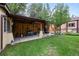 Relaxing covered patio featuring wooden beams, string lights, and an inviting seating area at 1470 S Yates St, Denver, CO 80219