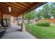 Relaxing covered patio with string lights and a view of the lush backyard at 1470 S Yates St, Denver, CO 80219