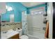 This bathroom features blue walls, a tub with shower, and a window for great natural light at 41 Cortez St, Denver, CO 80221