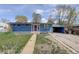 Charming single-story home with blue siding, red door, and driveway with carport and some grass at 41 Cortez St, Denver, CO 80221