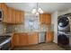 Bright kitchen features wood cabinets, granite countertops, stainless steel appliances, and stacked washer/dryer at 41 Cortez St, Denver, CO 80221