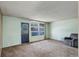 Bright living room with neutral carpet, windows, and an exterior door and a comfortable armchair at 41 Cortez St, Denver, CO 80221