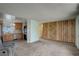 Open floor plan with kitchen and living room with neutral carpet and decorative wood paneling at 41 Cortez St, Denver, CO 80221
