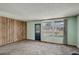 Spacious living room boasts neutral carpet, bright windows, and decorative wood paneling with exterior door at 41 Cortez St, Denver, CO 80221
