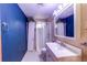 Basement bathroom with shower, vanity, and blue walls at 929 S Nile Way, Aurora, CO 80012