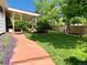 Lush backyard with landscaped flowerbed, green lawn, stone walkway, and covered back porch at 16308 E Wyoming Dr, Aurora, CO 80017