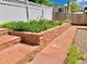 Landscaped garden bed featuring red stone, a brick walkway, and a lush green garden at 16308 E Wyoming Dr, Aurora, CO 80017