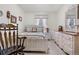 Cozy bedroom featuring a wooden bed frame, vintage furniture, and a window with sheer curtains at 16308 E Wyoming Dr, Aurora, CO 80017