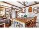 Rustic dining room showcasing wood beams, hardwood table, and open access to other living spaces at 16308 E Wyoming Dr, Aurora, CO 80017