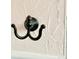 Close up of bronze metal hook mounted to a textured wall at 16308 E Wyoming Dr, Aurora, CO 80017