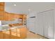 Galley style kitchen with light wood cabinets and appliances at 5648 E Greenwood Pl, Denver, CO 80222