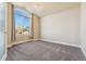 Bright bedroom with a large arched window, soft carpet, neutral paint, and chandelier style lighting at 1208 S Valentia Ct, Denver, CO 80247