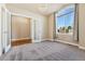 Bedroom featuring plush carpeting, large arched window with curtains, and decorative overhead lighting fixture at 1208 S Valentia Ct, Denver, CO 80247