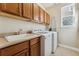 The laundry room features storage cabinets and a utility sink at 1208 S Valentia Ct, Denver, CO 80247