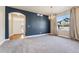 Living room with a blue accent wall, plush carpeting, a chandelier lighting fixture, and a bright window at 1208 S Valentia Ct, Denver, CO 80247