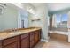 Bathroom showcasing double vanity with granite counters, shower, and large soaking tub at 1208 S Valentia Ct, Denver, CO 80247